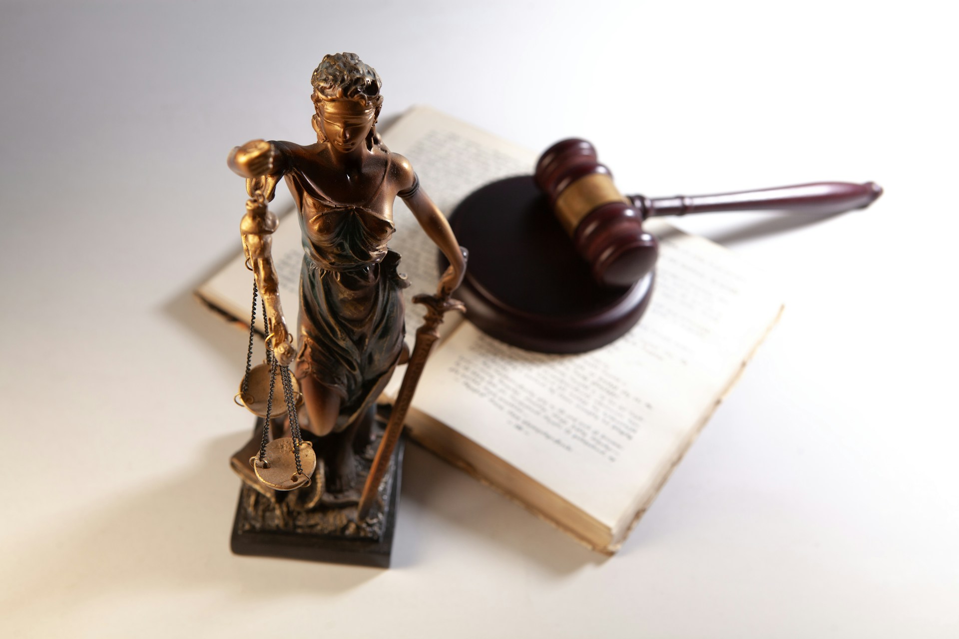 justice with balance figurine next to book with gavel on top