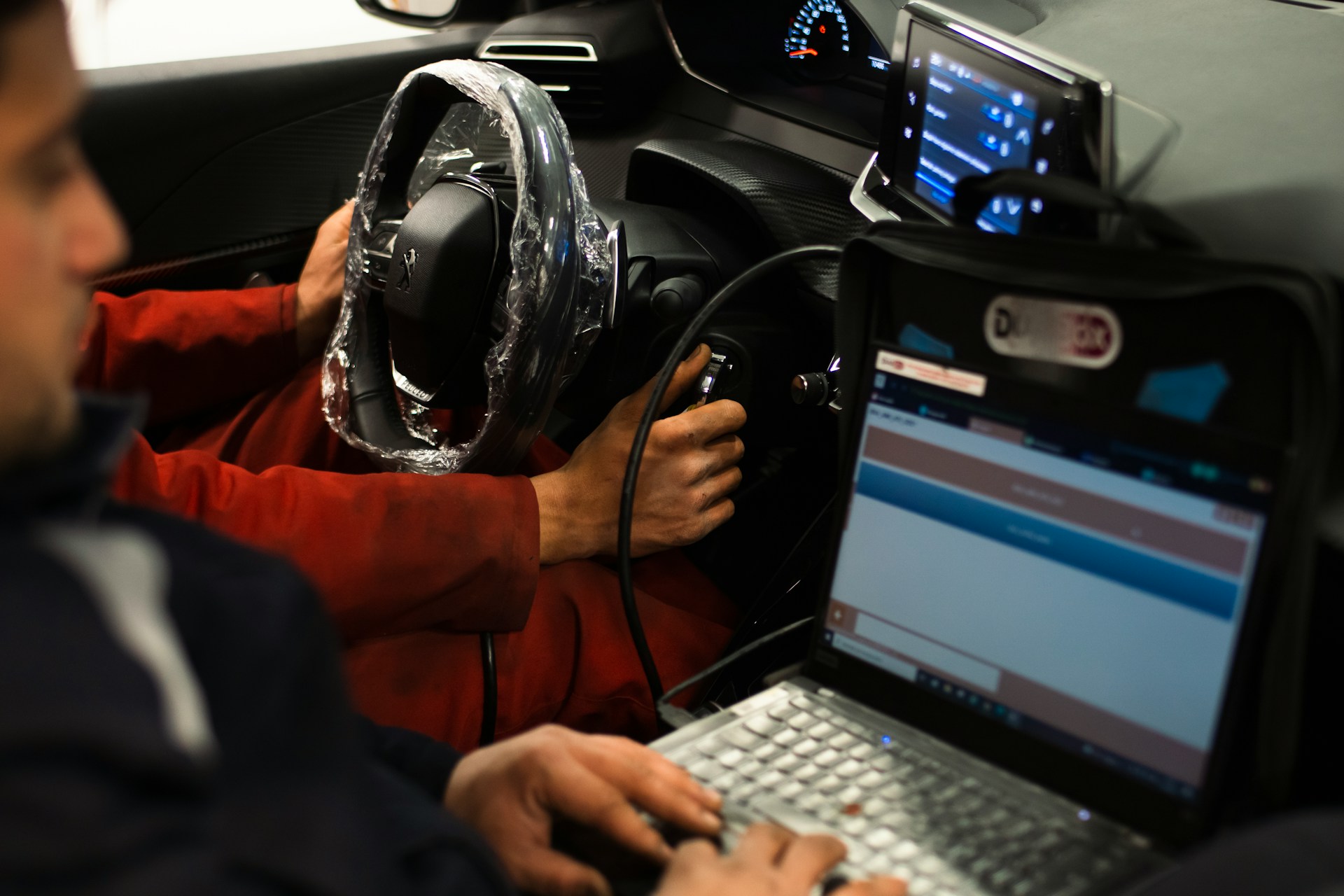 vehicle testing two people inside vehicle, one with a computer monitoring vehicle performance