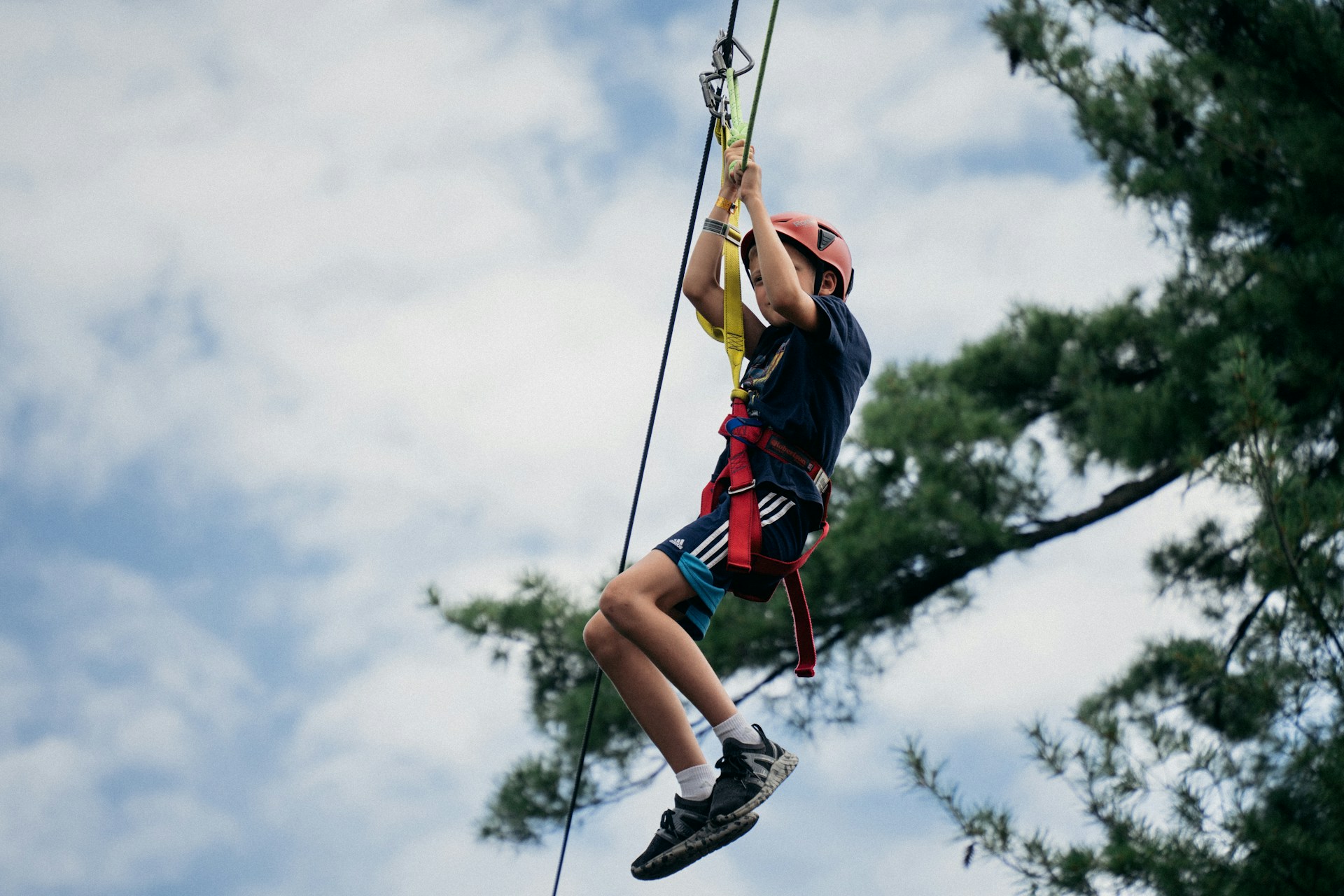 young-zipliner young zipliner with protective gear including helmet and harness with sky background