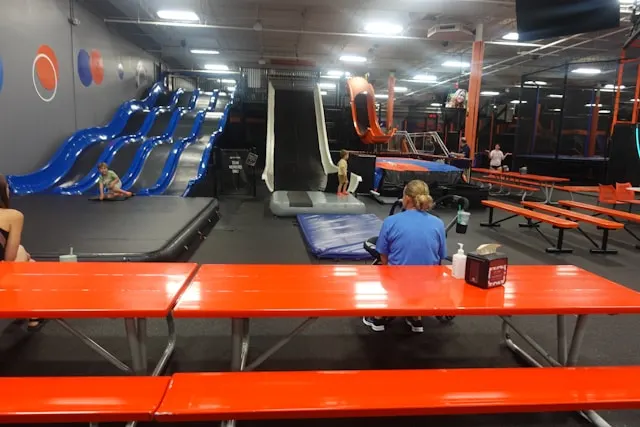 indoor trampoline park with slides with participants at tables