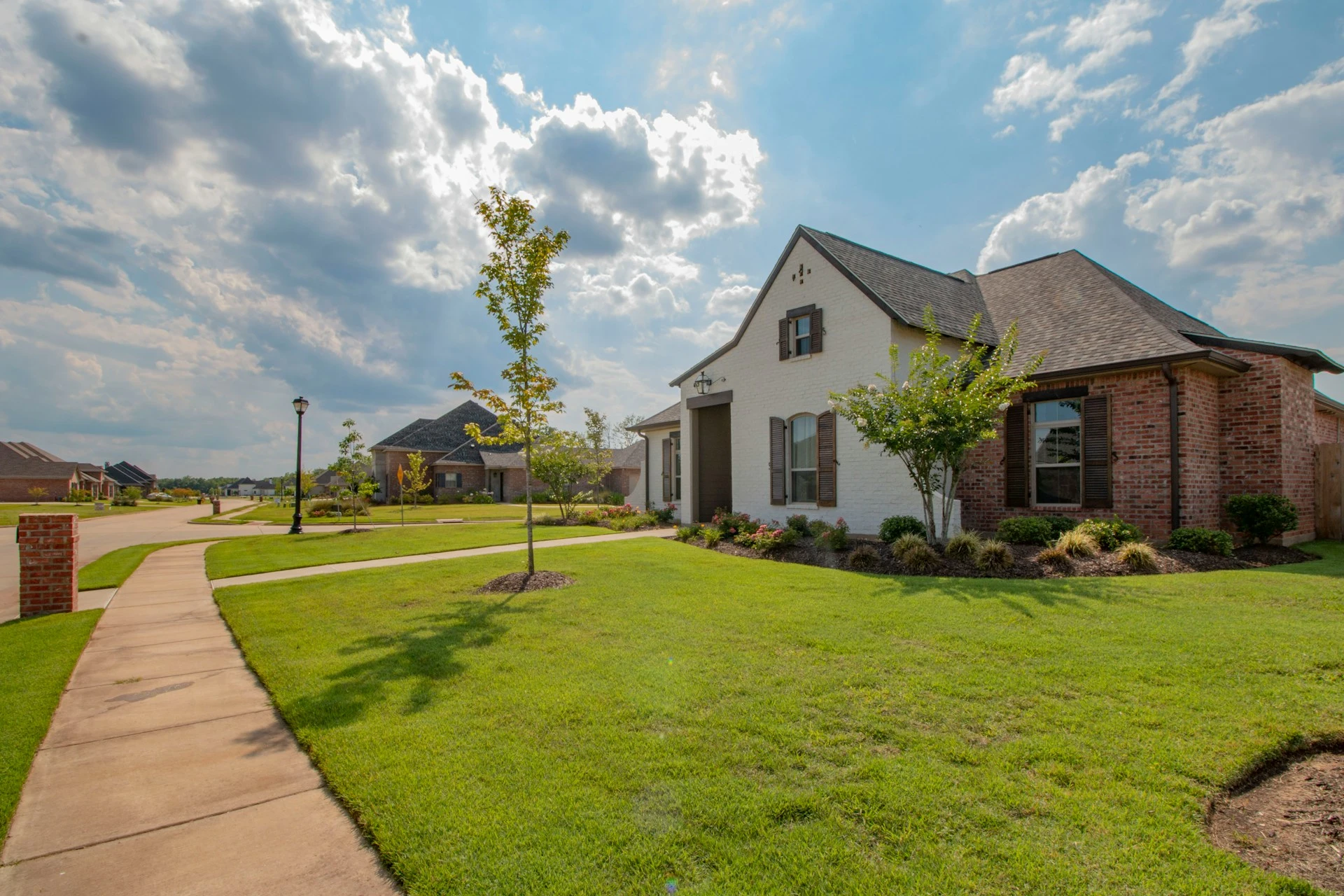 estate and trust expert witness home with yard and partly cloudy sky in background