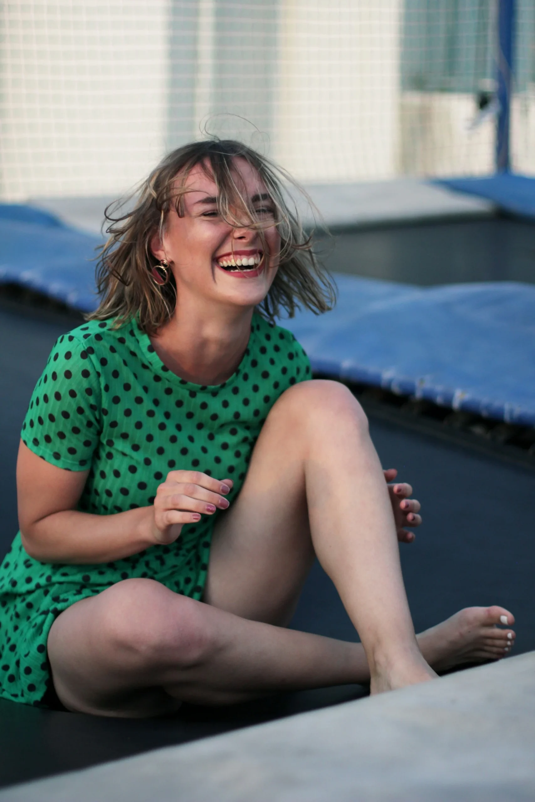 laughing-girl-on-trampoline- laughing girl sitting on trampoline outside Indoor trampoline park expert witness