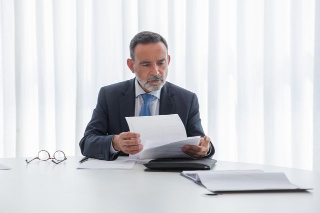 man-looking-at-documents expert witness researching with document in hand
