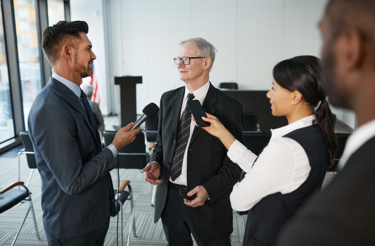 people in suits discussing facts and opinions one person holding a microphone