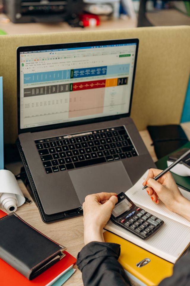 person at desk with laptop, calculator and notebook overlooking financial transactions estate and trust expert witness