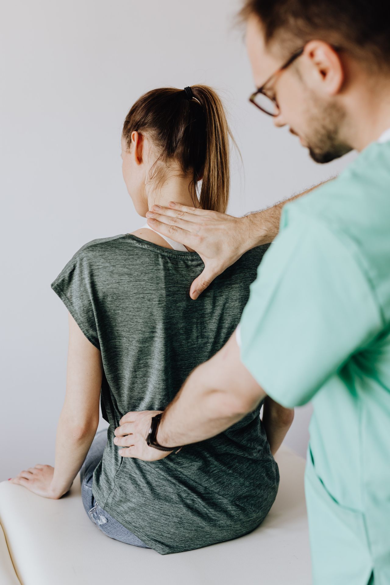 physical-therapist-measuring-hand physical therapist who could be a physical therapist expert witness using hands on patient's back